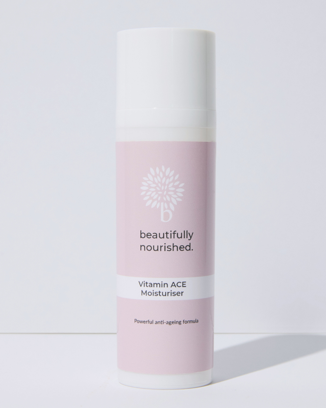 Skincare bottle labeled 'beautifully nourished' on a light background