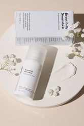 Skincare product with packaging on a beige plate with flowers showing beautifully nourished eye treatment for radiant refreshed under eyes