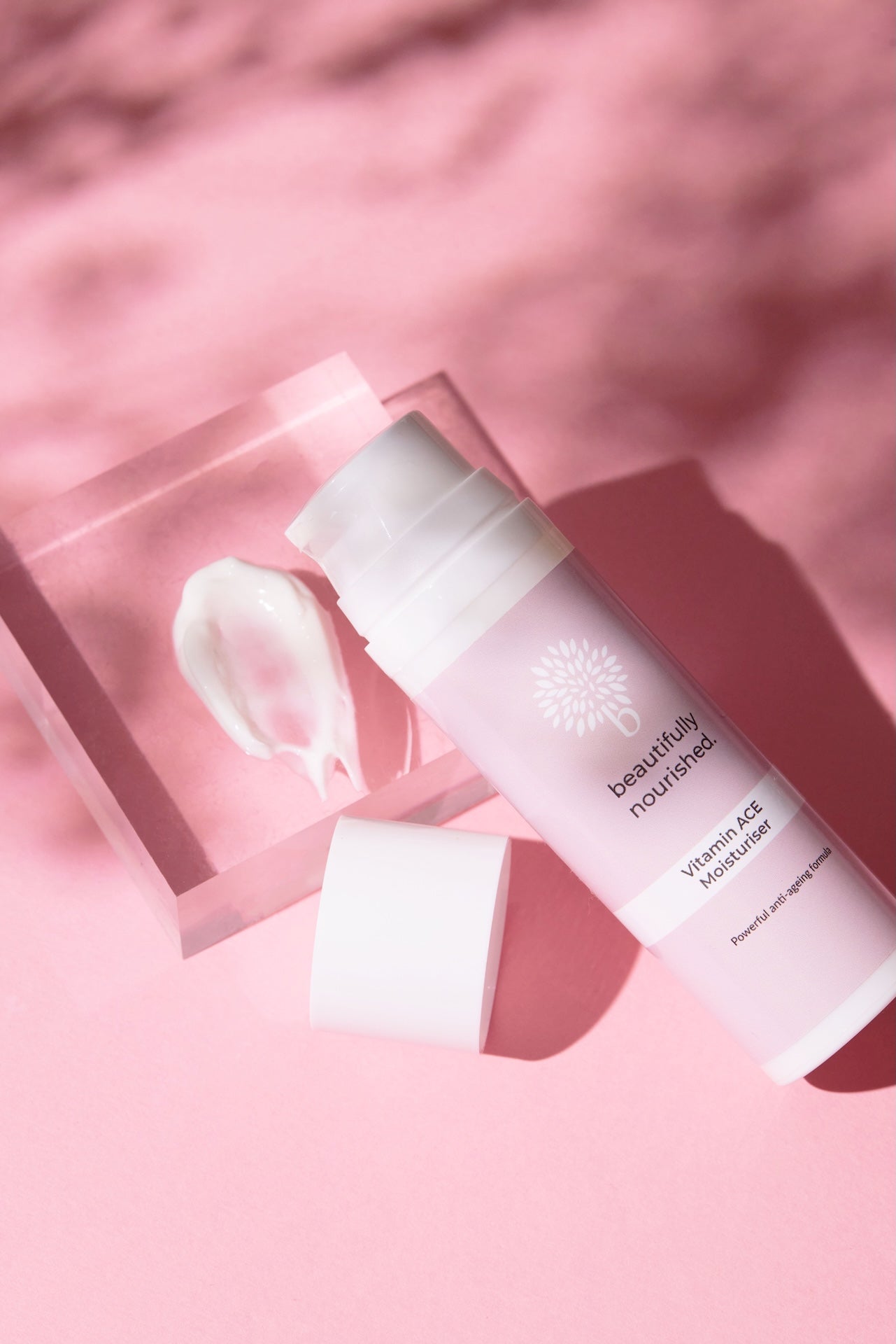 Skincare product of beautifully nourished vitamin ACE moisturiser for bright, hydrated skin on a pink background