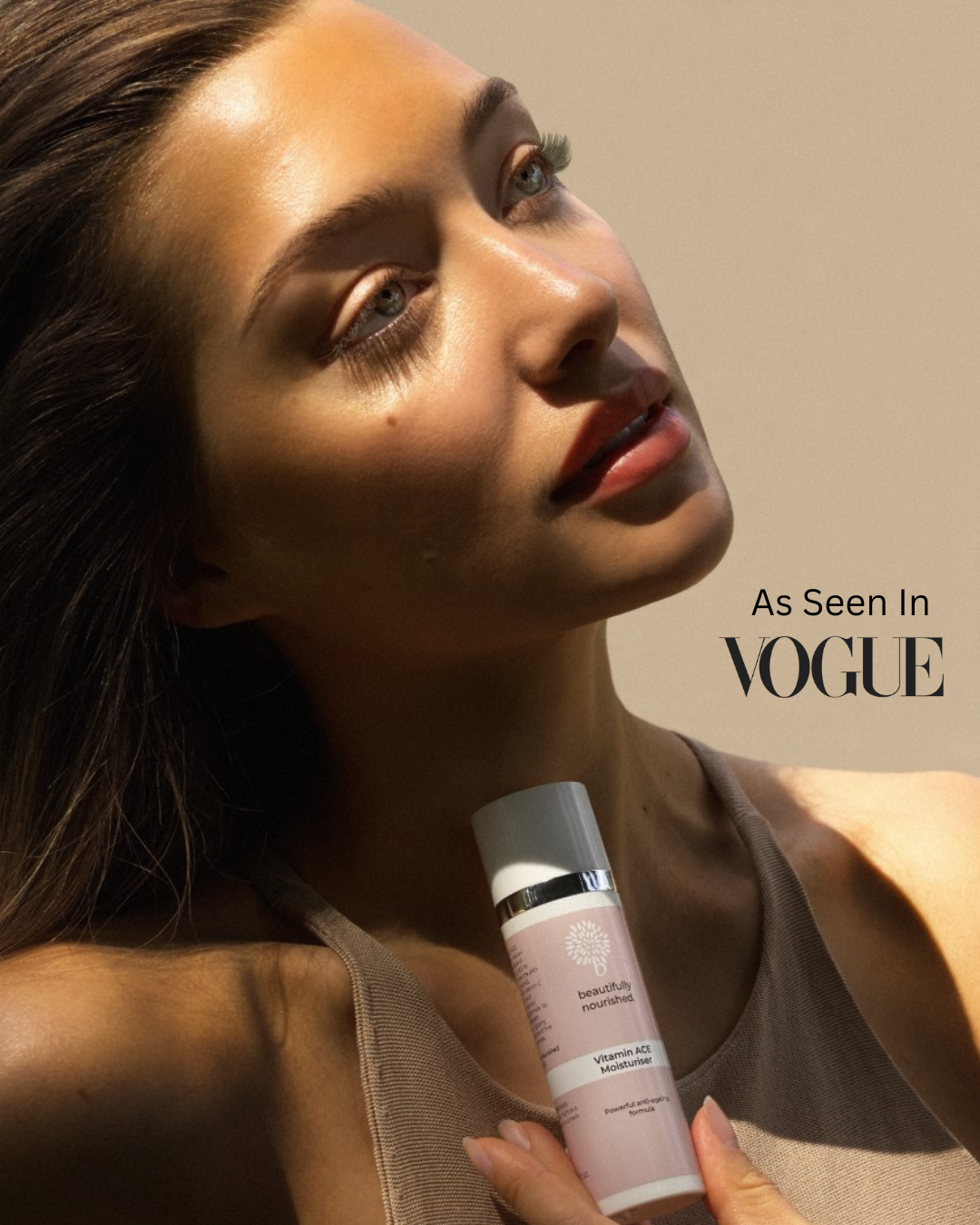 Woman holding a premium skincare product with 'Vogue' branding in the background