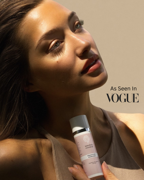 Woman holding a premium skincare product with 'Vogue' branding in the background