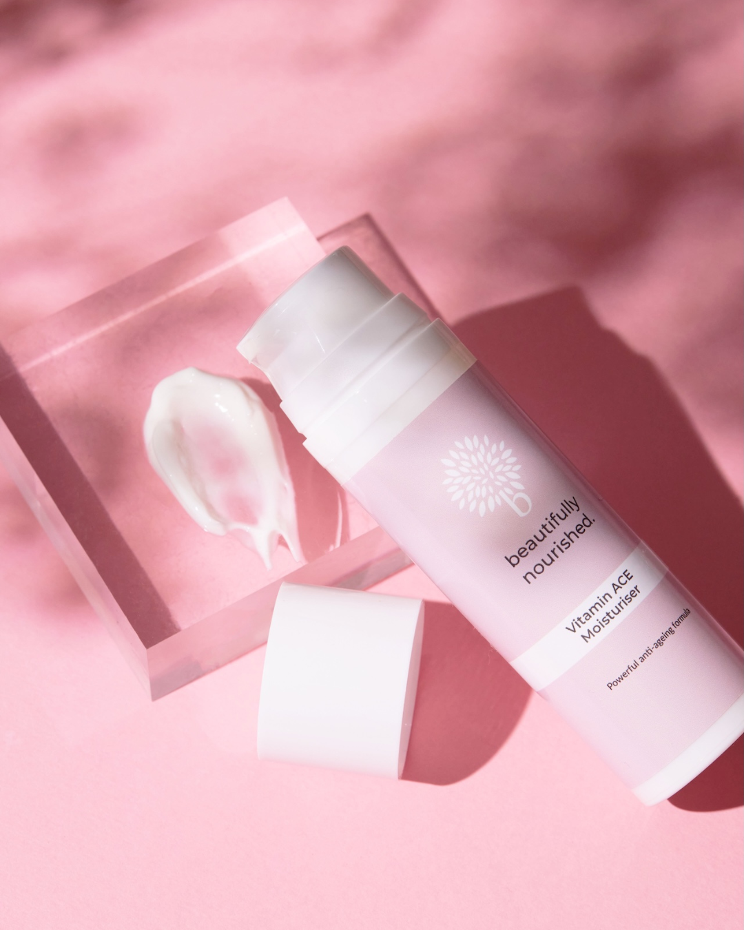 Skincare product of beautifully nourished vitamin ACE moisturiser for bright, hydrated skin on a pink background