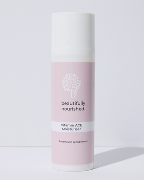Skincare bottle labeled 'beautifully nourished' on a light background